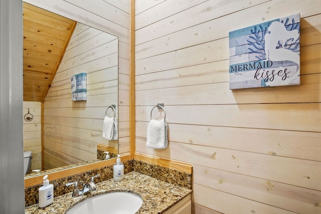 bathroom featuring wooden walls and vaulted ceiling