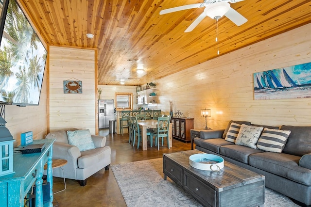 living room featuring wood walls, a wealth of natural light, and concrete floors