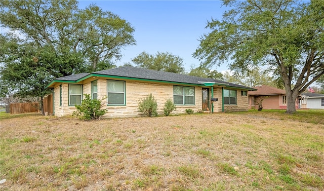 single story home with a front yard and fence