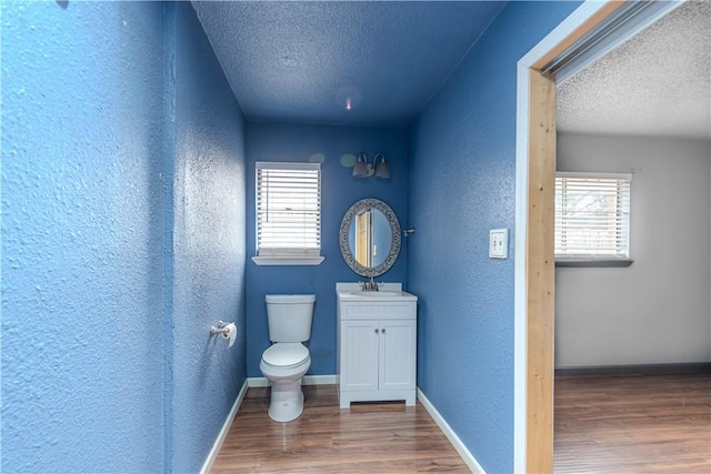 bathroom featuring hardwood / wood-style flooring, vanity, a textured ceiling, and toilet