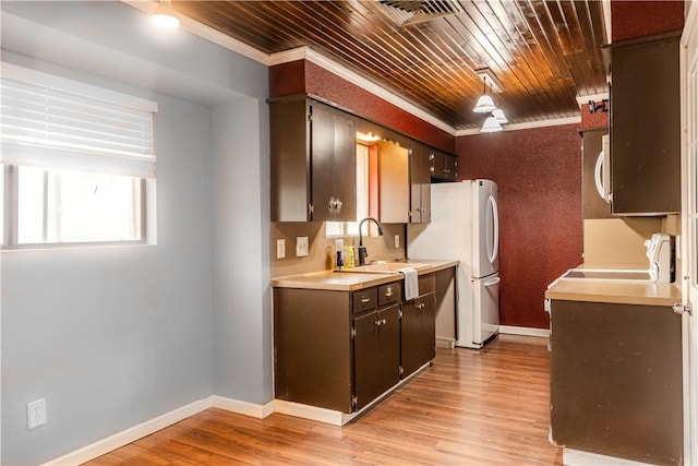 kitchen with dark brown cabinetry, ornamental molding, range, and sink