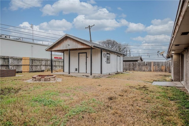 view of outbuilding with an outdoor fire pit and a lawn