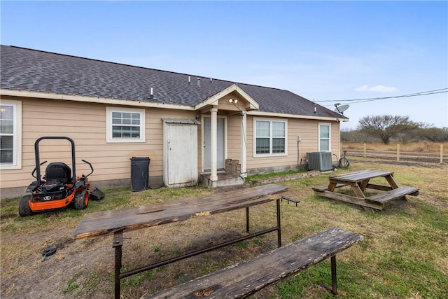 view of front facade featuring a front yard and central AC unit