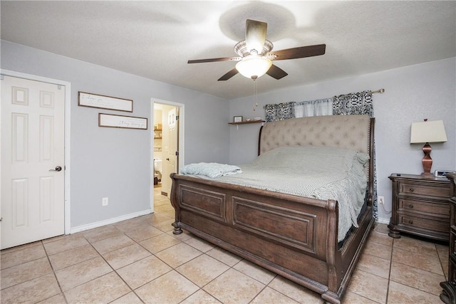 bedroom with ceiling fan, light tile patterned flooring, and ensuite bath