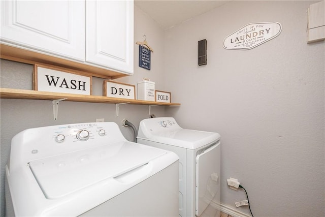 washroom with washer and dryer and cabinets