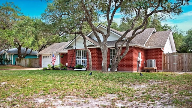 view of front facade with an attached garage, a front lawn, fence, and brick siding