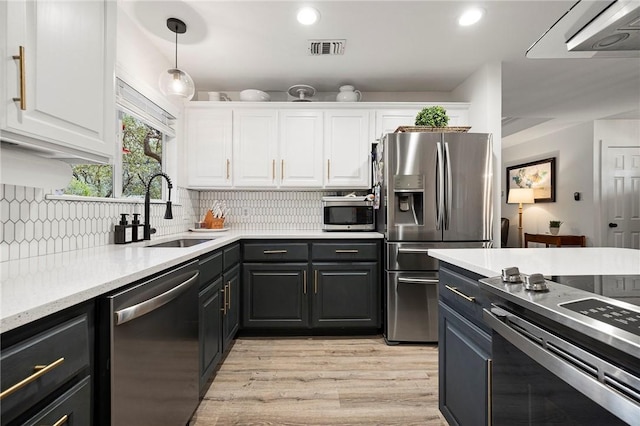 kitchen featuring a sink, stainless steel appliances, white cabinetry, and visible vents