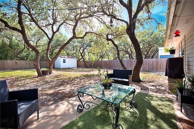 view of patio with a fenced backyard, an outbuilding, and a storage shed