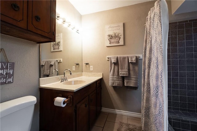 bathroom featuring toilet, tile patterned flooring, walk in shower, and vanity