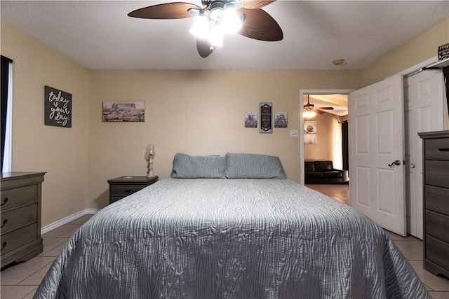 tiled bedroom with a textured ceiling and ceiling fan