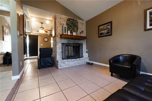 tiled living room with lofted ceiling, a brick fireplace, a textured ceiling, and ceiling fan