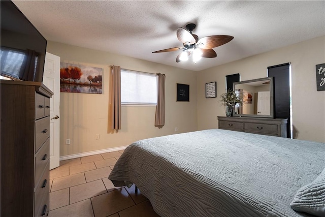 tiled bedroom featuring a textured ceiling and ceiling fan