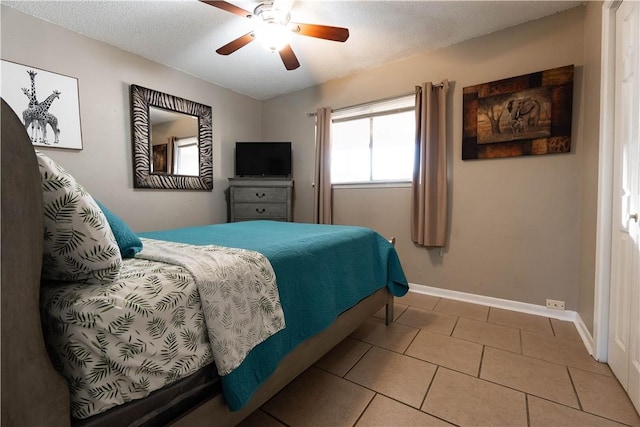 tiled bedroom featuring a textured ceiling and ceiling fan