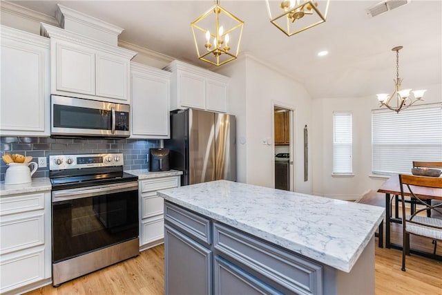 kitchen with visible vents, white cabinets, appliances with stainless steel finishes, a notable chandelier, and tasteful backsplash