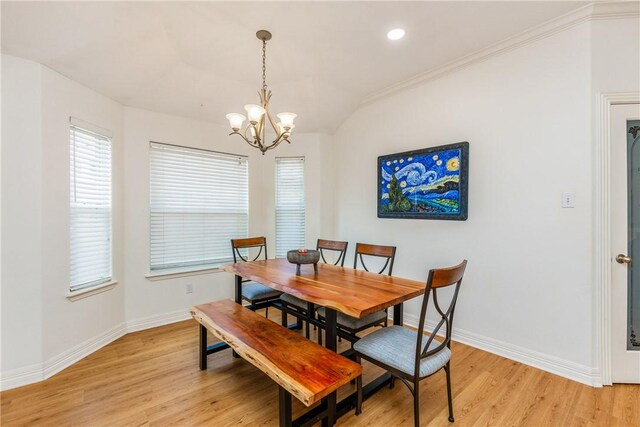 dining room featuring a chandelier, baseboards, light wood-style flooring, and vaulted ceiling