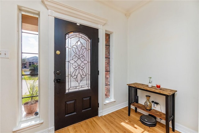 entrance foyer with crown molding, light wood-style floors, and baseboards