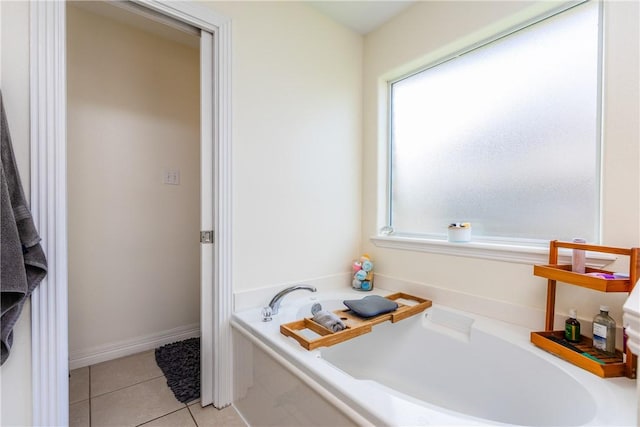 full bathroom with baseboards, a bath, and tile patterned flooring