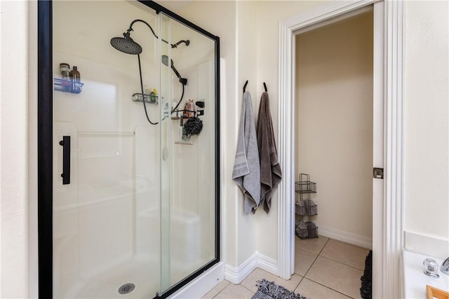 full bathroom featuring tile patterned floors, baseboards, and a shower stall