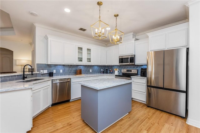 kitchen featuring visible vents, a sink, backsplash, white cabinetry, and appliances with stainless steel finishes