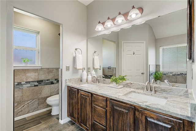 5921 Tapestry Dr, Corpus Christi, TX 78414 - full bath with wood finished floors, double vanity, toilet, tile walls, and wainscoting