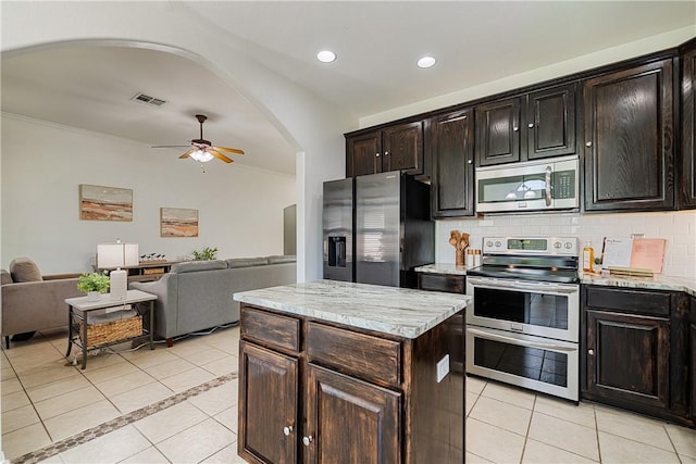 5921 Tapestry Dr, Corpus Christi, TX 78414 - kitchen with appliances with stainless steel finishes, light tile patterned floors, open floor plan, ceiling fan, and arched walkways