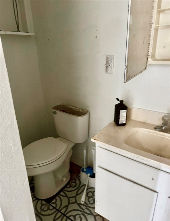 bathroom with tile patterned flooring, vanity, and toilet