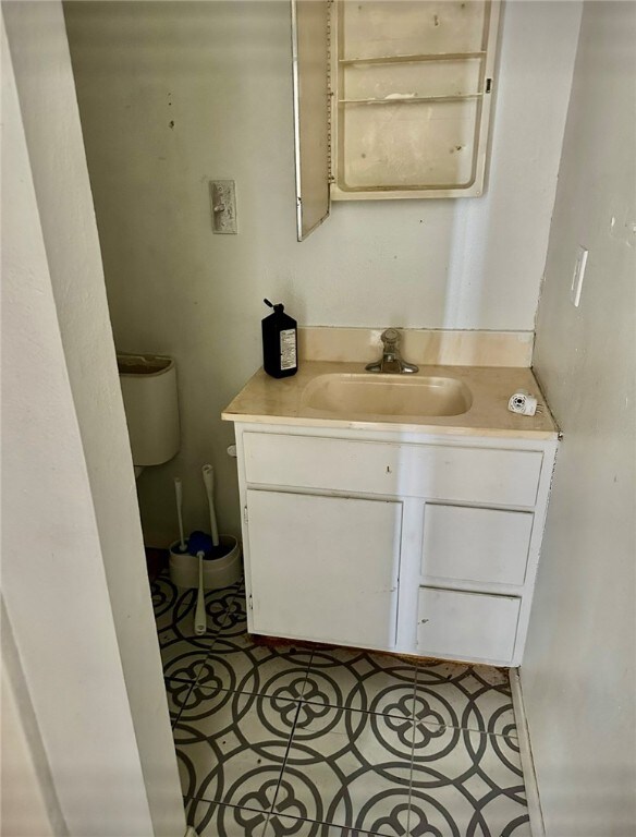 bathroom featuring toilet, vanity, and tile patterned flooring