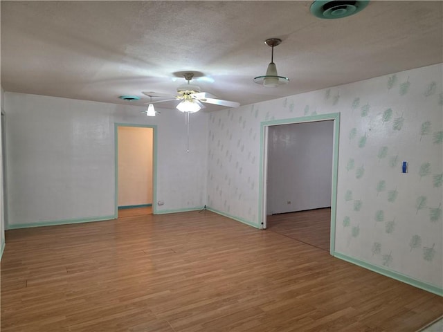 325 S Saunders St S, Aransas Pass, TX 78336 - unfurnished room with a ceiling fan, wallpapered walls, baseboards, and light wood finished floors