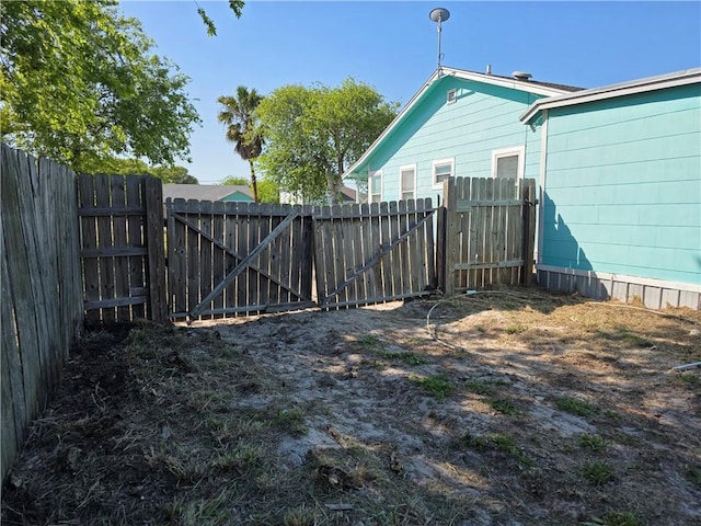 325 S Saunders St S, Aransas Pass, TX 78336 - view of yard featuring a fenced backyard and a gate