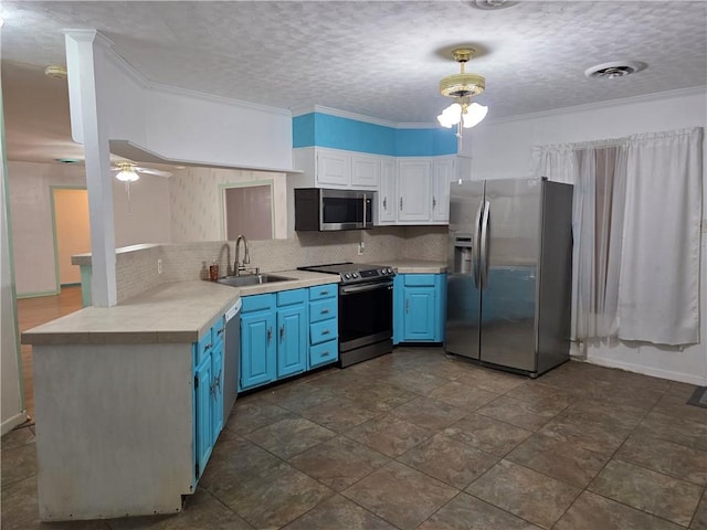 325 S Saunders St S, Aransas Pass, TX 78336 - kitchen featuring white cabinets, a sink, stainless steel appliances, decorative backsplash, and blue cabinets