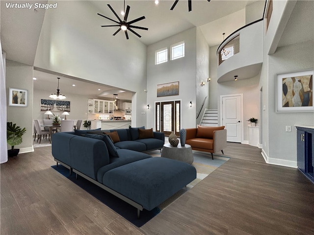 living room with a high ceiling, dark hardwood / wood-style flooring, and plenty of natural light