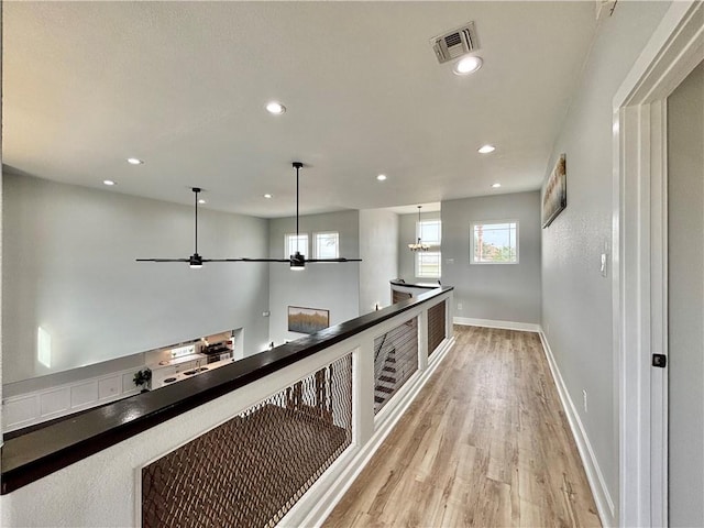 hall with light hardwood / wood-style flooring and plenty of natural light