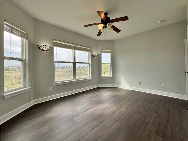 unfurnished room featuring plenty of natural light, ceiling fan, and dark hardwood / wood-style flooring