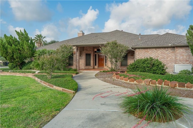 8018 Mt Zion, Corpus Christi, TX 78413 - ranch-style home featuring brick siding, a front yard, a chimney, a shingled roof, and a porch