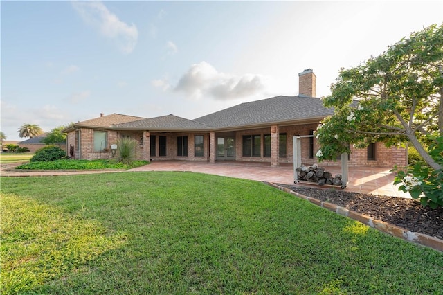 8018 Mt Zion, Corpus Christi, TX 78413 - back of house featuring brick siding, a patio area, a yard, and a chimney