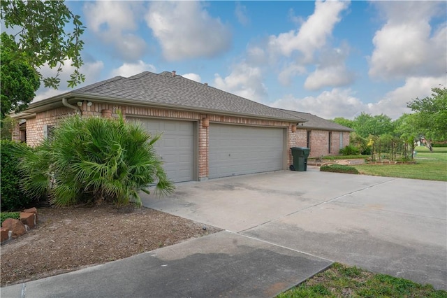 8018 Mt Zion, Corpus Christi, TX 78413 - view of side of property with concrete driveway, an attached garage, brick siding, and a shingled roof