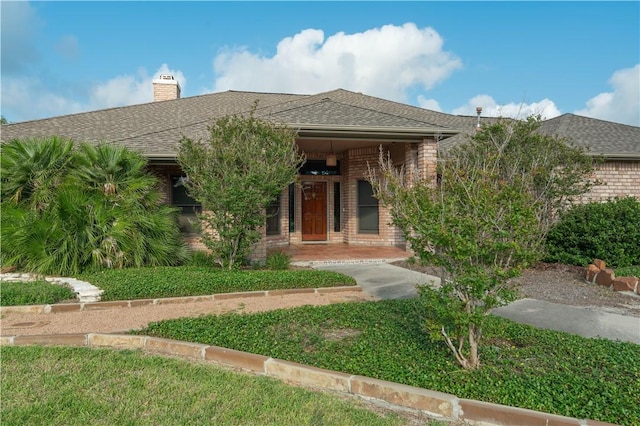 8018 Mt Zion, Corpus Christi, TX 78413 - view of front of house featuring brick siding, a chimney, and a shingled roof