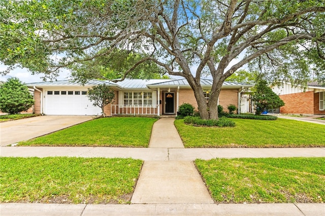 4410 Marie St, Corpus Christi, TX 78411 - view of front facade featuring brick siding, an attached garage, driveway, a standing seam roof, and a front yard