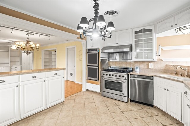4410 Marie St, Corpus Christi, TX 78411 - kitchen featuring appliances with stainless steel finishes, a chandelier, under cabinet range hood, a sink, and ornamental molding