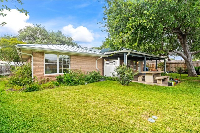 4410 Marie St, Corpus Christi, TX 78411 - view of front of property with a patio, brick siding, and a standing seam roof