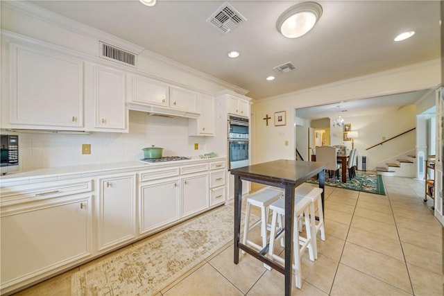 kitchen with white cabinetry, visible vents, and tile counters