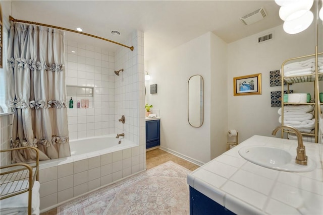 bathroom with visible vents, vanity, tile patterned flooring, and tiled shower / bath combo