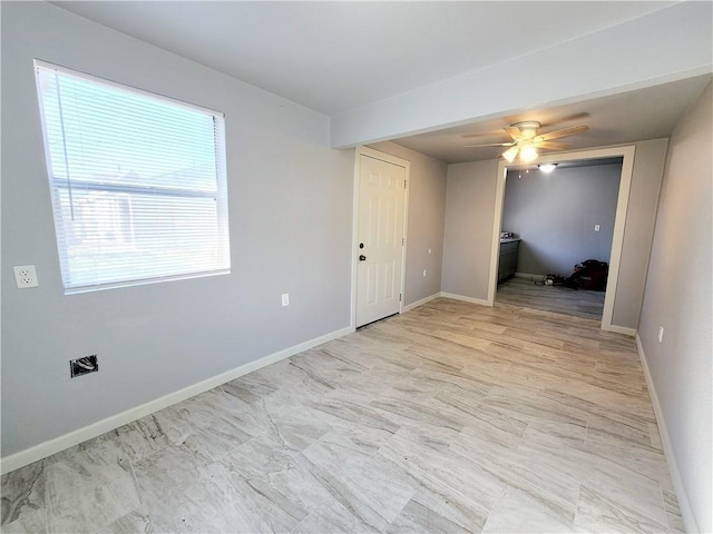 empty room featuring ceiling fan and plenty of natural light