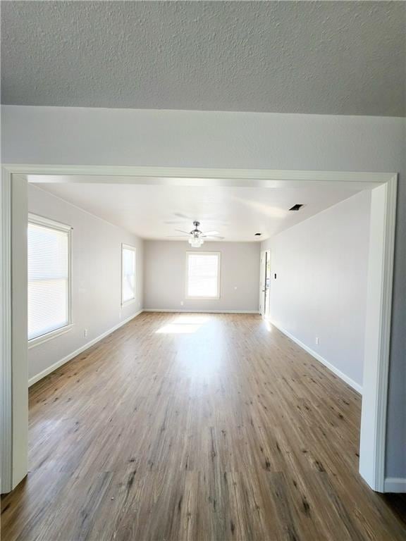 empty room with wood-type flooring, a textured ceiling, and ceiling fan