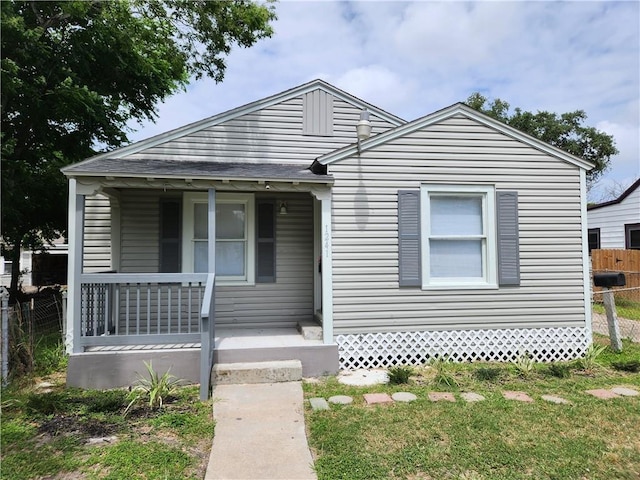 bungalow-style house with a front yard and covered porch