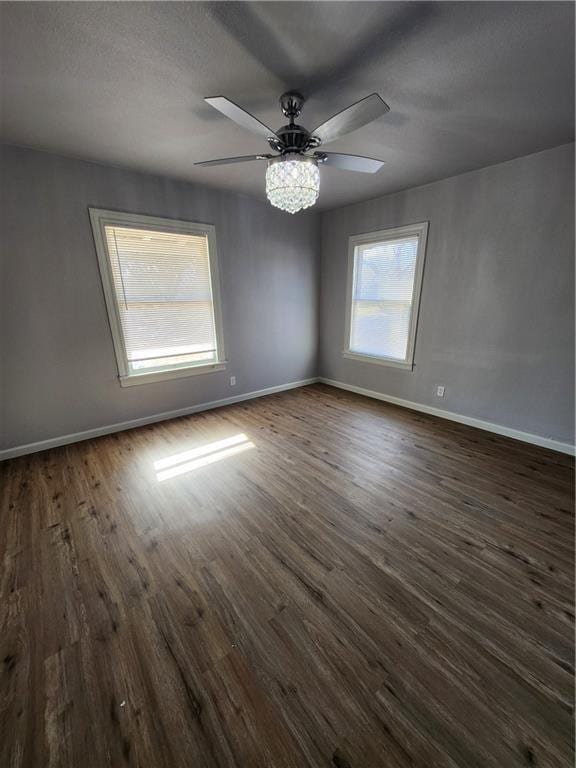 unfurnished room featuring ceiling fan and dark wood-type flooring