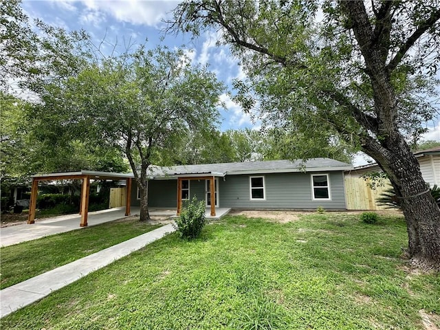 ranch-style house featuring driveway, a front yard, and an attached carport