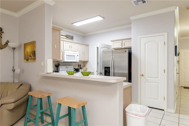 kitchen featuring a breakfast bar, kitchen peninsula, crown molding, white appliances, and light tile patterned floors