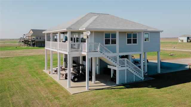 299 Bay Dr, Palacios, TX 77465 - back of property with stairs, a yard, a patio, roof with shingles, and a carport