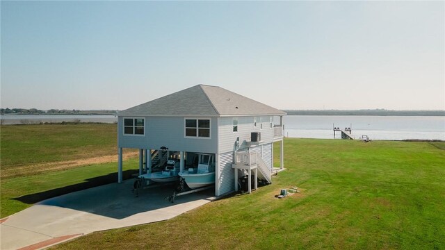 299 Bay Dr, Palacios, TX 77465 - rear view of house with driveway, stairs, a water view, a yard, and a carport